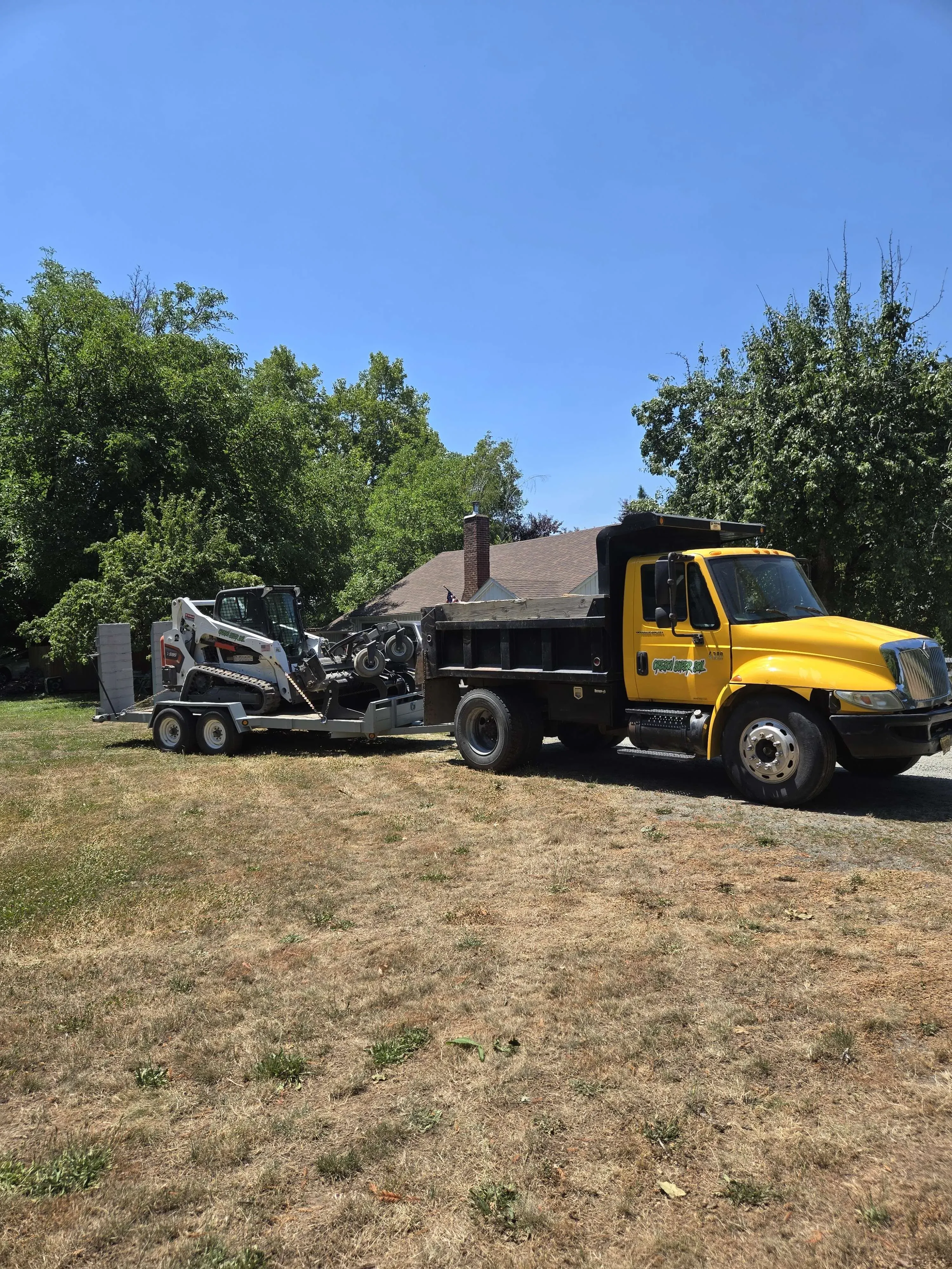 Dumptruck pulling Bobcat equipment on a trailer